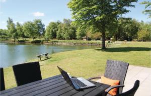 un ordenador portátil sentado en una mesa de picnic junto a un lago en 3 Bedroom Gorgeous Home In Ringkbing en Hee