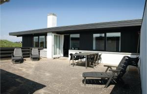 - un ensemble de chaises et de tables sur une terrasse dans l'établissement 2 Bedroom Beautiful Home In Pandrup, à Rødhus
