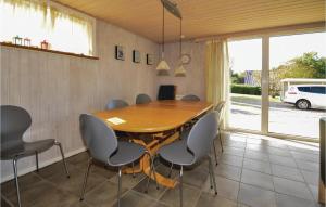 a dining room with a wooden table and chairs at 3 Bedroom Amazing Home In Fars in Hvalpsund
