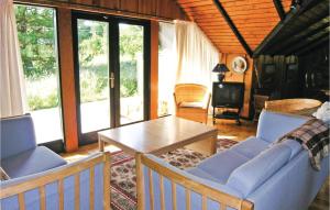 Slettestrandにある3 Bedroom Amazing Home In Fjerritslevのリビングルーム(青い椅子、テーブル付)