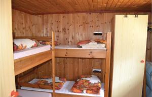 ÅlbækにあるNice Home In lbk With 2 Bedroomsのキャビン 二段ベッド3組が備わる客室です。