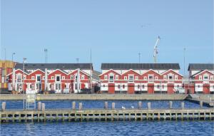 a row of red and white buildings next to the water at 1 Bedroom Lovely Home In Skagen in Skagen