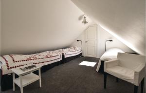 a attic room with four beds and a chair at Gorgeous Home In rbk With Wifi in Ørbæk