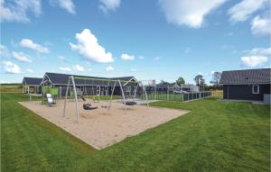 a playground with a swing set in a yard at Lovely Home In Grenaa With Sauna in Grenå +38 photos