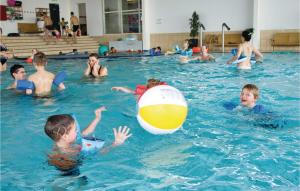 a group of children playing with a ball in a swimming pool at Marina Fiskenæs Feriepark in Gråsten