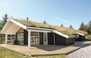 ブロックフスにあるCozy Home In Blokhus With Wifiの木のデッキ付草屋根の家