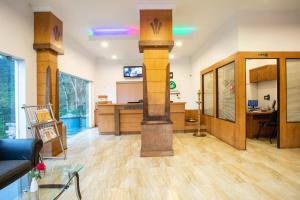 a living room with a column in the middle of a room at Monsoon Grande in Munnar