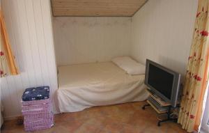Habitación pequeña con cama y TV. en 3 Bedroom Gorgeous Home In Vestervig en Vestervig