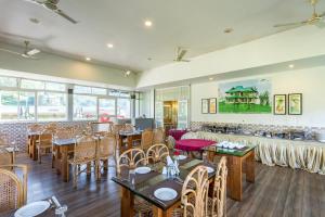 a restaurant with tables and chairs in a room at Monsoon Grande in Munnar