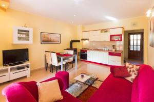 sala de estar con sofá rojo y cocina en Apartments Filip & Tara, en Poreč