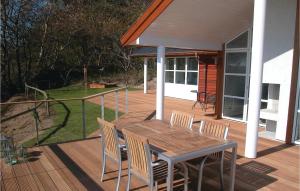 a wooden deck with a table and chairs on a house at Holiday Home Lersøvej in Rønne