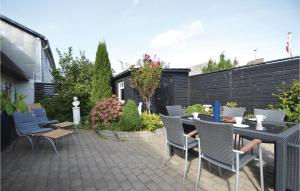 een patio met een tafel en stoelen en een hek bij Stunning Home In Hjer With Wifi in Højer