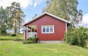 a red house with a white window in a yard at 2 Bedroom Lovely Home In Burseryd in Burseryd