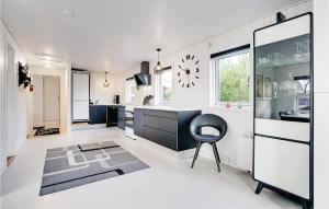 a kitchen with a black chair and a clock on the wall at Three-Bedroom Holiday Home In Henne in Henne Strand