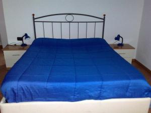 un letto con un piumone blu sopra di esso di Villa Stefy a Dervio