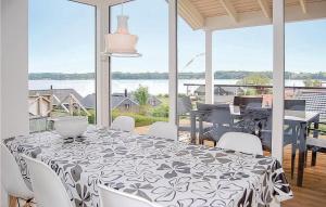 comedor con mesa y vistas al agua en Awesome Home In Hejls With Kitchen, en Hejls