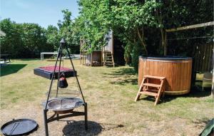 a garden with a swing set and a wooden barrel at Two-Bedroom Holiday Home In Ronde in Rønde