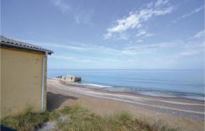 a building on a beach next to the ocean at Four-Bedroom Holiday Home In Frostrup in Frøstrup