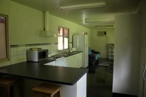 a kitchen with a counter top and a refrigerator at Spring Homestead in Howard Springs