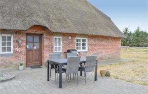 a table and chairs in front of a brick building at Two-Bedroom Apartment In Romo in Rømø Kirkeby