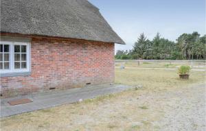a brick building with a window and a potted plant at Two-Bedroom Apartment In Romo in Rømø Kirkeby