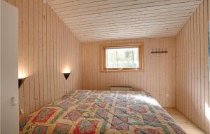 a bedroom with a bed in a room with a window at Holiday Home Skovsangervej Nexø V in Spidsegård