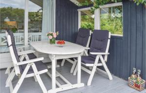 スナーヴィグにあるBeautiful Home In Ringkbing With Kitchenの白いテーブルと椅子が置かれたポーチ