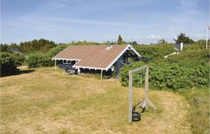 a house in a field with a basketball hoop at Beautiful Home In Ringkbing With Kitchen in Søndervig