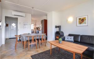a living room with a couch and a table and a kitchen at Holiday Home Horns Bjerge Blåvand Iv in Blåvand