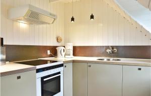 a white kitchen with a sink and a stove at Æsken in Nørre Lyngvig
