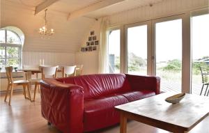 a living room with a red leather couch and a table at Æsken in Nørre Lyngvig