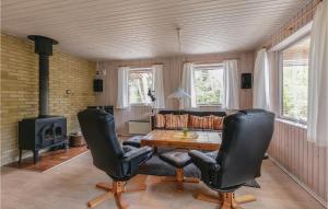 a living room with a table and chairs and a stove at Stunning Home In Nex With 3 Bedrooms, Sauna And Wifi in Balke