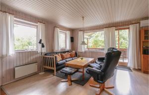 a living room with a couch and a table at Stunning Home In Nex With 3 Bedrooms, Sauna And Wifi in Balke