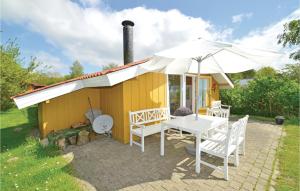 a yellow house with a table and an umbrella at Holiday Home Birkely Nysted Denm in Nysted +12 photos