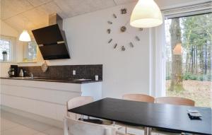 プランデにあるAmazing Home In Brande With 1 Bedroomsのキッチン(テーブル、壁掛け時計付)