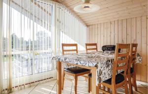 Un comedor con mesa y sillas y grandes ventanales. en Holiday Home Brombærvænget Xi, en Hejls