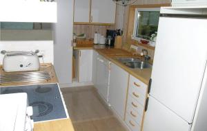 a small kitchen with a sink and a refrigerator at Amazing Home In Skagen With 3 Bedrooms, Sauna And Wifi in Hulsig