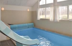 una piscina con un tobogán en una habitación en 5 Bedroom Stunning Home In Hornbk en Dronningmølle