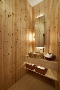 a bathroom with wooden walls and a sink and a mirror at GRAND CHARIOT Hokutoshichisei 135° in Awaji
