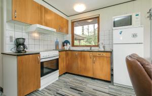 Una cocina con gabinetes de madera y un refrigerador blanco. en Holiday Home Sletten Vi, en Helberskov