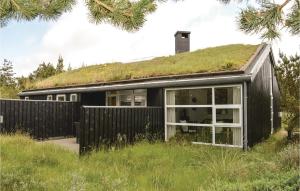 a black house with a grass roof at Holiday Home Granvej Rømø Ii in Bolilmark +19 photos