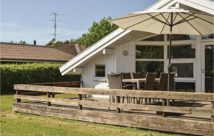 a deck with a table and an umbrella at Awesome Home In Humble With 3 Bedrooms, Sauna And Wifi in Humble