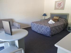 a bedroom with a bed and a desk at Dalby Manor Motor Inn in Dalby