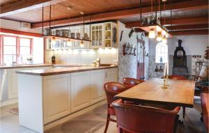 cocina grande con mesa de madera y sillas en 3 Bedroom Amazing Home In Kirke Eskilstrup en Kirke Eskilstrup