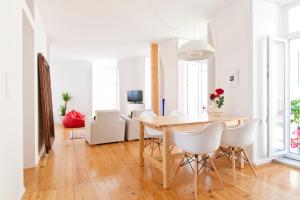a dining room with a table and white chairs at Bairrus Lisbon Apartments - Graça in Lisbon