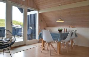 HavrvigにあるBeautiful Home In Hvide Sande With 2 Bedrooms And Wifiのダイニングルーム(テーブル、白い椅子付)