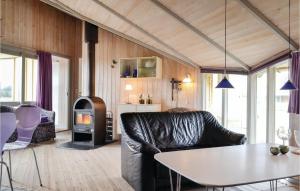 BjerregårdにあるBeautiful Home In Hvide Sande With Wifiのリビングルーム(ソファ、テーブル、コンロ付)