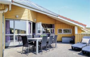 BjerregårdにあるBeautiful Home In Hvide Sande With Wifiの家の前のパティオ(テーブル、椅子付)
