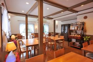 a dining room with wooden tables and chairs at Anise Garden in Hakuba