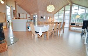 una sala da pranzo con tavolo bianco e sedie in legno di 4 Bedroom Awesome Home In Lkken a Løkken
